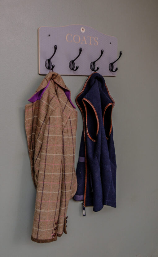 Grey wall mounted coat rack with black hooks and engraving of coats. option of personalisation