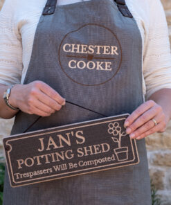 holding a potting shed sign