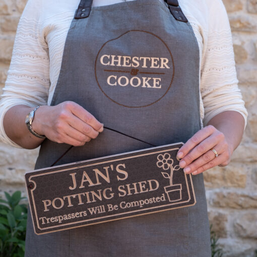 holding a potting shed sign