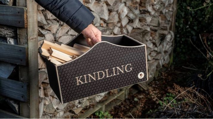 Wooden kindling box held in front of a log store