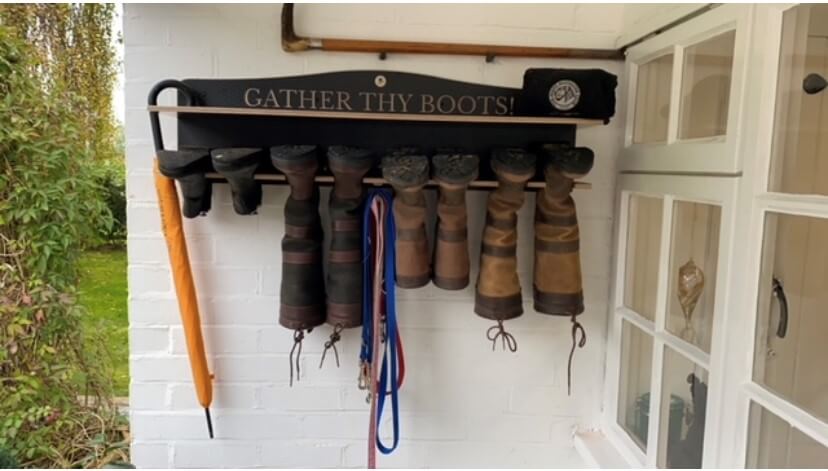 Welly Rack hanging on a white wall in a outside porch storing wellies & umbrellas 