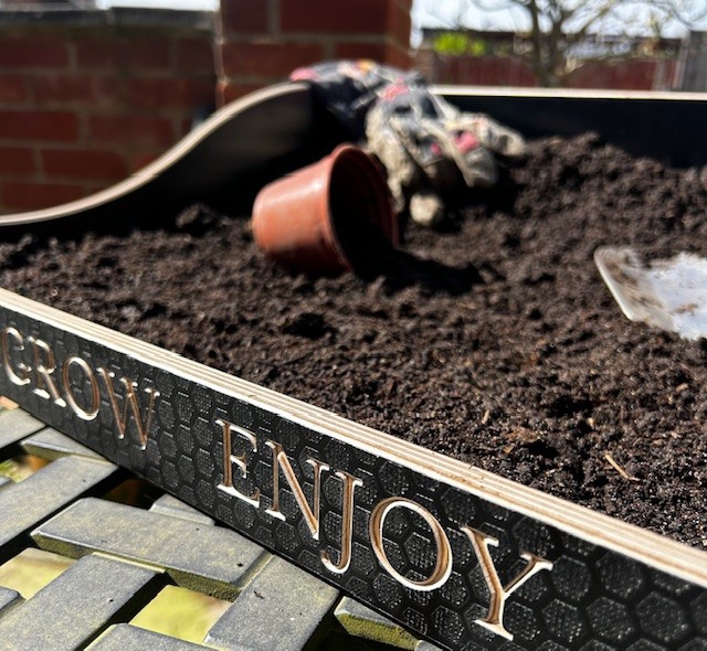 A wooden potting tray in use.