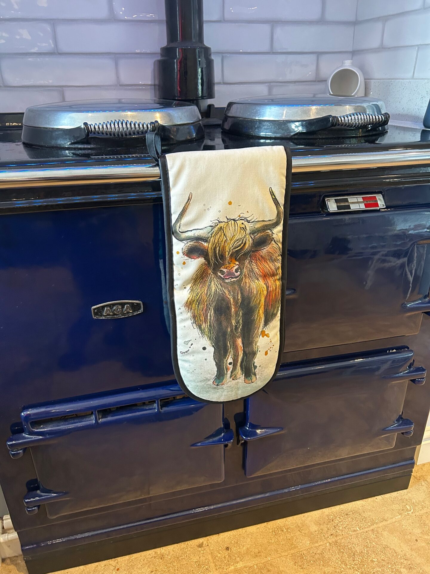 highland cow oven mitts on a navy aga